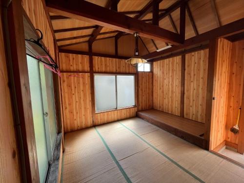 an empty room with a large window and wooden walls at Yotsubaso Bungalow Village - Vacation STAY 85281v in Moriya