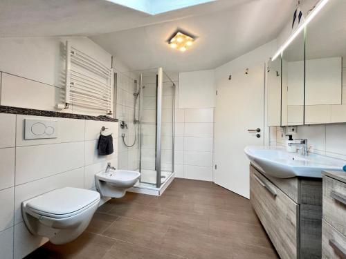 a white bathroom with a toilet and a sink at Ferienapartment Huber in Oberkirch
