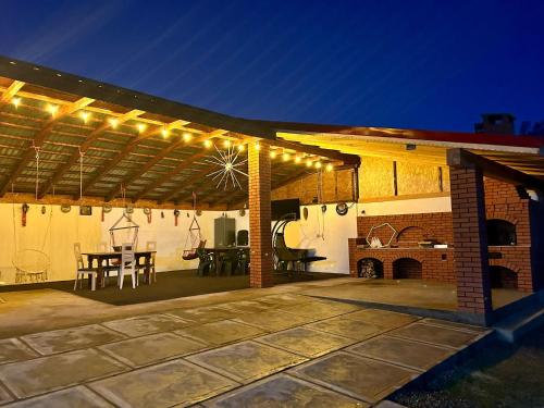 eine Terrasse mit Beleuchtung, einem Tisch und einem Kamin in der Unterkunft Casa Andra in Baia de Fier