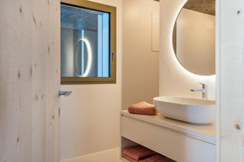 a bathroom with a sink and a mirror at Lena Dolomites Gartensuite in Villnoss