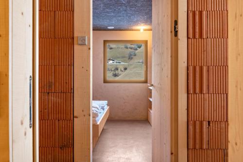 a hallway with a room with a bed and a painting at Lena Dolomites Gartensuite in Villnoss