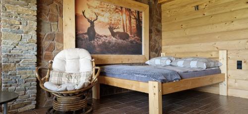 a bedroom with a bed and a picture of deer at Babiogórskie Domki in Lipnica Wielka