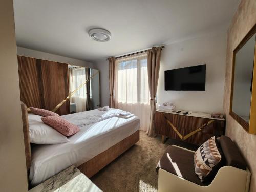 een hotelkamer met een bed en een televisie bij Къща за гости Vip House 