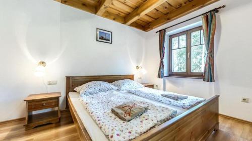 a bedroom with a bed with a wooden frame and a window at Csodaszarvas Vendégházak in Rábahidvég