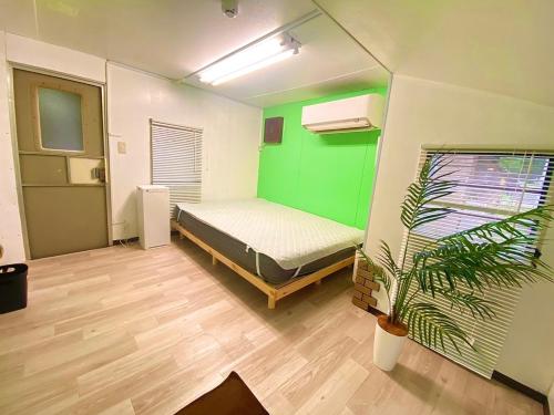 a bedroom with a bed and a green wall at BULLs Camp - Vacation STAY 56022v in Narusawa