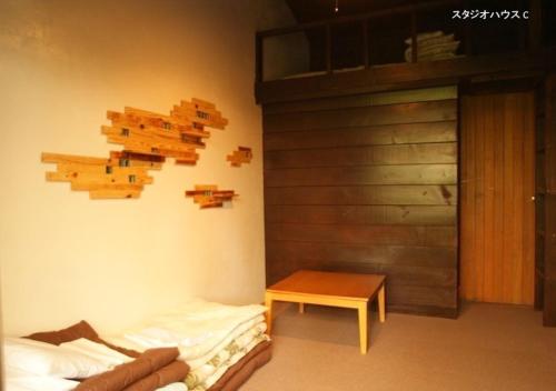 a room with a bed and a table and a wall at NAKADAKI ART VILLAGE - Vacation STAY 41948v in Shiigi