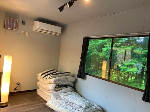 um quarto com uma janela e duas cadeiras em BULLs Camp - Vacation STAY 56021v em Narusawa