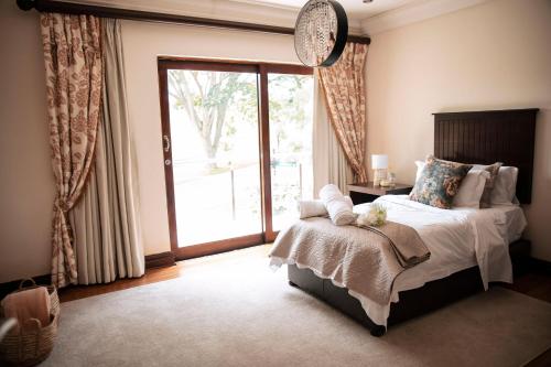 a bedroom with a bed and a large window at White River Country Estate - Self Catering - AMH Home in White River