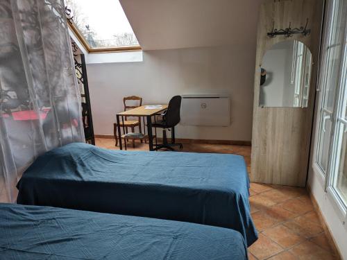 a bedroom with a bed and a table with chairs at LE GITE DE RICHEMONT in Lachapelle-Saint-Pierre