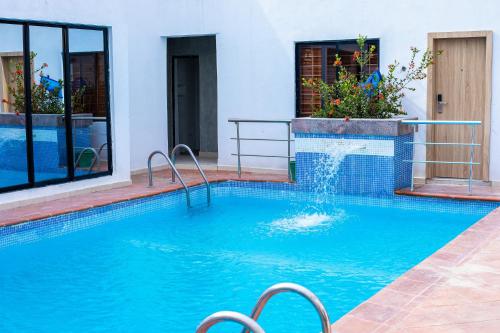 una piscina con una fuente en un edificio en Homegate Resort, en Lekki