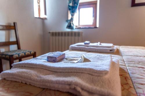 1 dormitorio con 2 toallas encima de la cama en La Taberna di Rocca Calascio, en Calascio