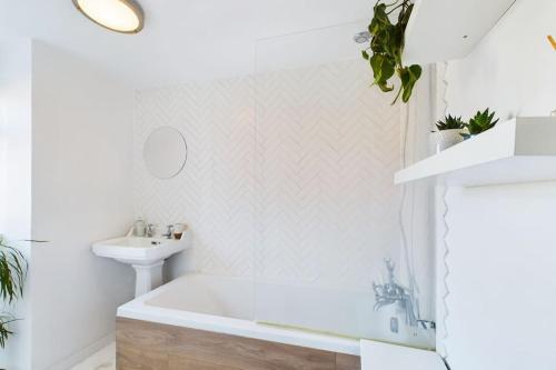 a white bathroom with a tub and a sink at Melody Rowe One Bed Free Wi-Fi Garden Fireplace 