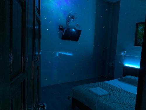 um quarto azul com uma cama e uma televisão na parede em Khách sạn minion 2 em Thuan An