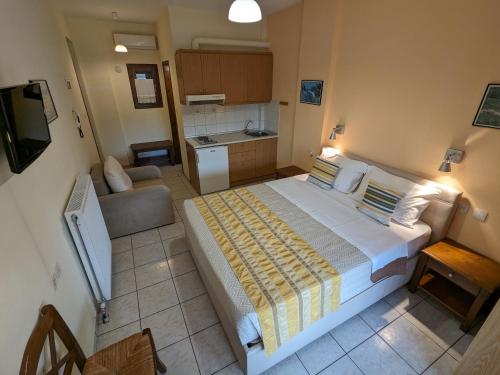 1 dormitorio con 1 cama grande y cocina en Pagaseon Rooms and Apartments en Kala Nera