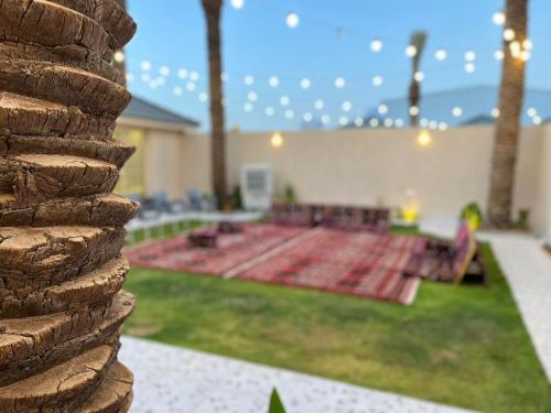 un patio trasero con una alfombra en la hierba en منتجع شمس en Ilbaras