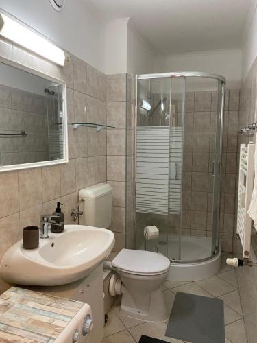 een badkamer met een wastafel, een toilet en een douche bij Márton Residence with FREE PARKING in Boedapest