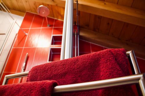 Ferienwohnung Am Loferwasser في اريت ايم فينكل: حمام به مناشف حمراء على رف مناشف