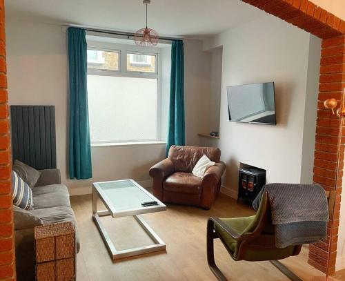 ein Wohnzimmer mit einem Sofa, Stühlen und einem Tisch in der Unterkunft House in Ebbw Vale in Ebbw Vale