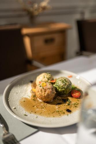 a plate of food with meatballs and vegetables on a counter at Pension Höfler - Fernblick in Schenna