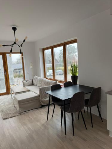 a living room with a table and a couch at Nybyggd lgh 100m till stranden, 150m till golfbana ,samt gemensam pool och spa in Beddinge
