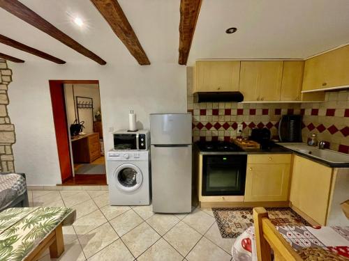 une cuisine avec un réfrigérateur et une machine à laver dans l'établissement ANNECY 2 Fg Sainte Claire vieille ville 4pers 3 étoiles proche lac et gare, à Annecy