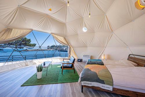a bed in a tent with a view of the water at La-gum - Vacation STAY 42361v in Inatori