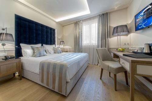 a hotel room with a bed and a desk and a computer at Grand Hotel Slavia - Adults only in Baška Voda