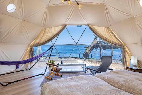 a room with a bed and a hammock in a tent at La-gum - Vacation STAY 23965v in Inatori