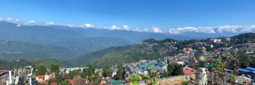 uitzicht op een stad met bergen op de achtergrond bij Hotel Aliment Darjeeling in Darjeeling