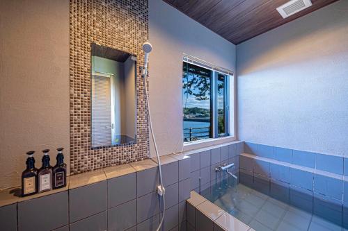 łazienka z wanną i oknem w obiekcie La-gum - Vacation STAY 42137v w mieście Inatori