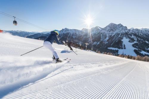 a person is skiing down a snow covered slope at App Piz de Plaies -ciasa Lavarella in San Vigilio Di Marebbe