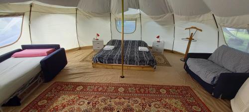 una camera con un letto e un divano in una tenda di terrebio Chalet a Visnadello
