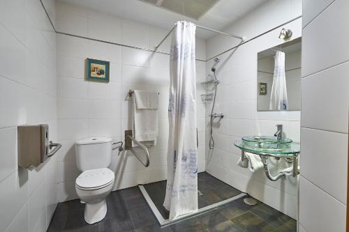 a bathroom with a toilet and a glass sink at Hotel Real de Illescas in Illescas