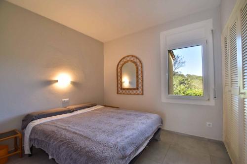 um quarto com uma cama e uma janela em Casa Riebie em Begur
