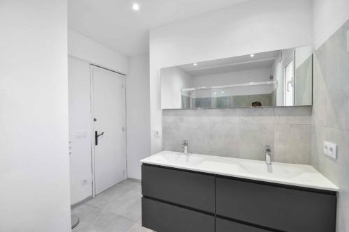 uma casa de banho branca com um lavatório e um espelho em Casa Riebie em Begur