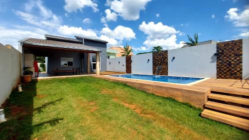 un patio trasero con piscina y una casa en Vivenda Bela Vista en Boituva