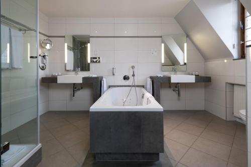 a large bathroom with two sinks and a tub at Martin's Klooster in Leuven