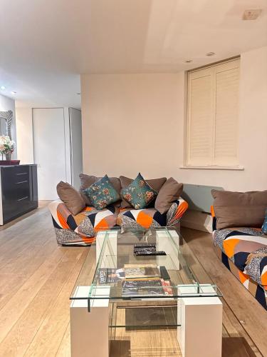 a living room with a couch and a glass table at Spacious Central London flat - 2BHK in London