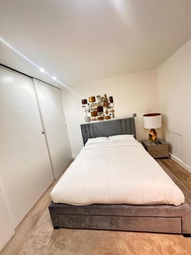 a bedroom with a large bed and a lamp at Spacious Central London flat - 2BHK in London