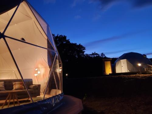 a glass igloo with a building in the background at Hotel Kiso Onsen Kogane no Yu Glamping Ontake - Vacation STAY 23987v in Shimotono