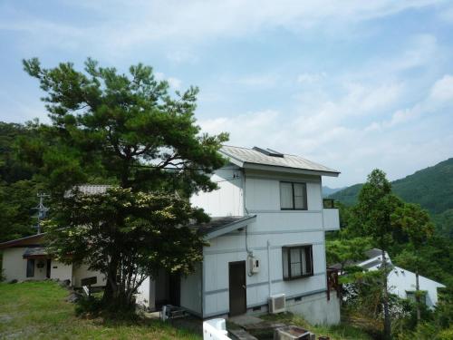 a white house on a hill with a tree at Ten Ten Go Shibu Kawa - Vacation STAY 41956v in Ono