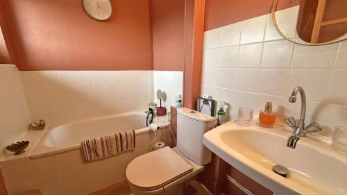 een badkamer met een toilet, een wastafel en een bad bij Villa gabrielle in Châteauponsac