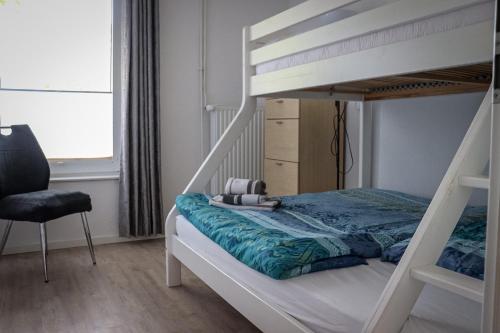 a bedroom with a bunk bed and a chair at Ferienhof Ostarle in Arle