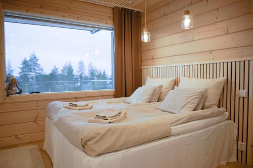 a large white bed in a room with a window at Villa Vaalea in Rovaniemi