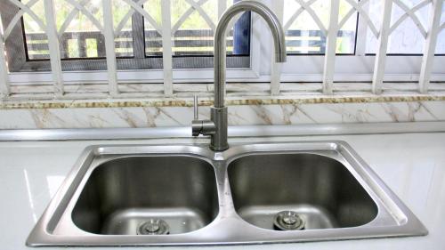 a stainless steel sink in a kitchen with a window at Tropical Oasis in Accra - 2 Bedroom Apartment in Accra