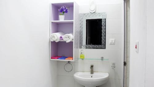 Baño blanco con lavabo y espejo en Beautiful 2-Bed Apartment in Accra en Accra