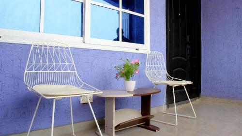 two chairs and a table with a vase of flowers at Tropical Oasis in Accra - 2 Bedroom Apartment in Accra