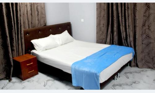 um quarto com uma cama com um cobertor azul em Beautiful 2-Bed Apartment in Accra em Acra