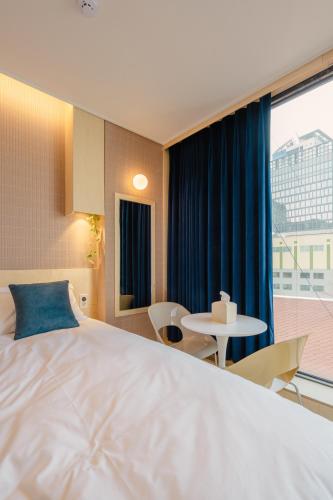 a hotel room with a large bed and a table at Hithere City Myeongdong in Seoul