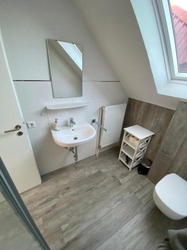 La salle de bains est pourvue d'un lavabo et d'un miroir. dans l'établissement Ferienhof Ostarle, à Arle